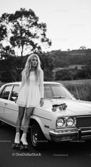Young woman in dress with roller skates by classic car
