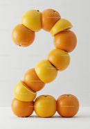 Number Two Formed by Fresh Citrus Fruits on White