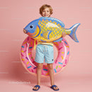 Happy boy holding inflatable fish and pool ring