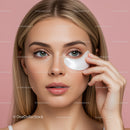 Woman applying moisturizer on her face with pink background