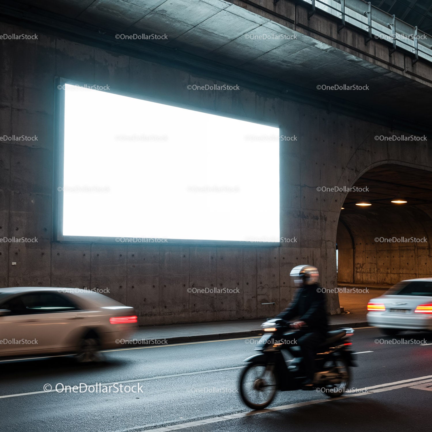 Motocyklista i samochody przejeżdżające obok oświetlonego billboardu
