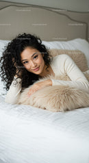 Relaxed woman with curly hair lying on cozy bed