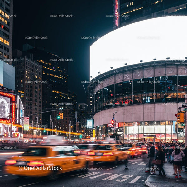 Zatłoczona miejska ulica z żółtymi taksówkami i jasnymi billboardami