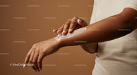 Woman Applying Lotion to Arm for Moisturizing Skin with Soft Texture