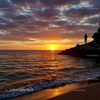 Beautiful Sunset over Calm Ocean with Silhouette of Person and Rocks
