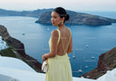 Elegant woman in yellow dress overlooking serene sea view