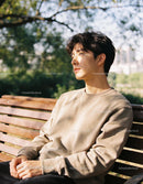 Young man relaxing peacefully on sunny park bench