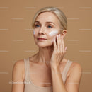 Elegant Mature Woman Applying Skincare Cream on Cheek