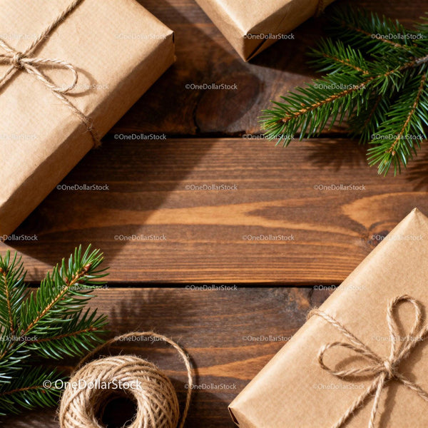Natural wrapped gifts with evergreen branches on wood