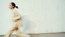 Stylish Woman in Motion Wearing Elegant Beige Outfit