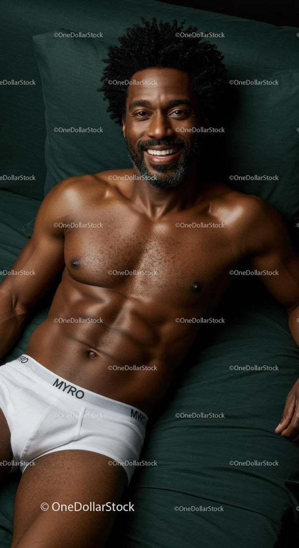 Smiling muscular man relaxing on dark green bedding