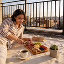 Woman enjoying a relaxed rooftop charcuterie and coffee