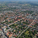 Aerial View of a Vibrant City with Red Roofs and Green Parks