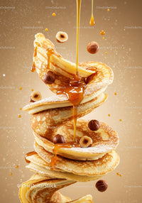 Stack of fluffy pancakes with hazelnuts and syrup drizzle