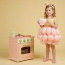 Little girl in balloon skirt enjoying tea party