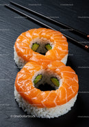 Fresh salmon sushi rings with avocado on black slate