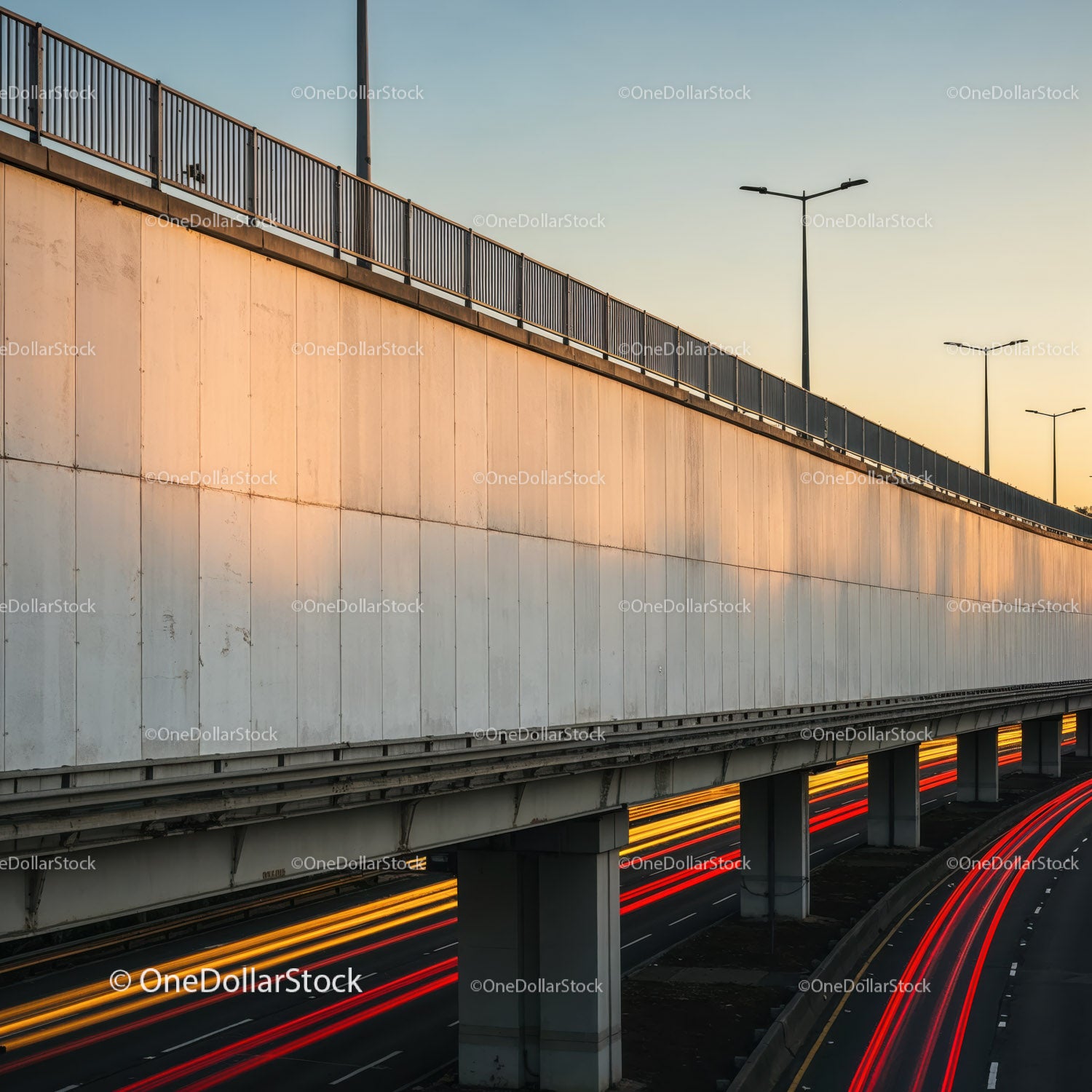 Betonowy wiadukt z latarniami ulicznymi i smugami świetlnymi o zachodzie słońca