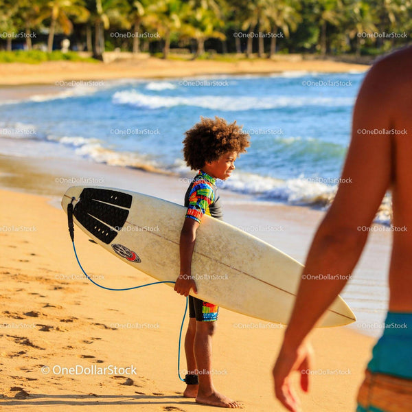 Young Boy Holding Surfboard on Sunny Beach Shore