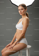 Elegant Young Woman Sitting in White Lingerie Studio Portrait