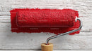 Red Paint Roller on Rustic Wooden Surface for Home Renovation