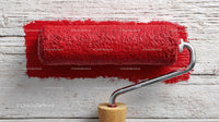 Red Paint Roller on Rustic Wooden Surface for Home Renovation