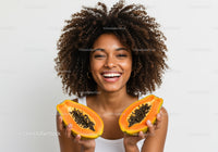 Joyful Woman with Fresh Papaya Halves in Bright Studio Portrait