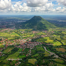 Tall Green Volcano Mountain Overlooking Vibrant Rural Village