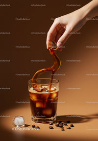 Pouring Cold Brew Coffee Over Ice Cubes in Glass