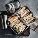 Ham and Lettuce Sandwiches in Aluminum Foil with Thermos on Brown Wooden Surface