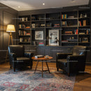 Cozy reading corner with leather chairs and bookshelf