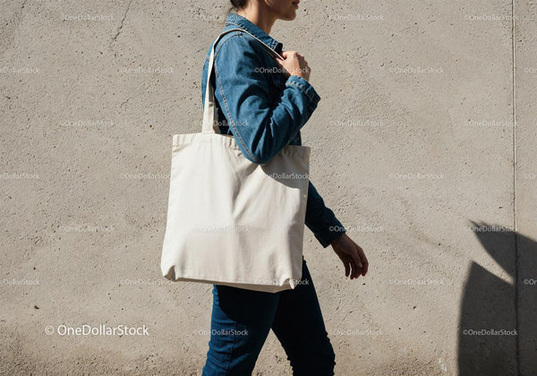 Woman carrying blank canvas tote bag outdoors JPG Mockup Image