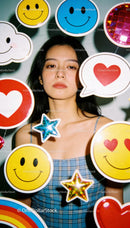 Thoughtful woman surrounded by colorful cheerful icons