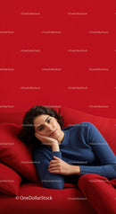Young Woman Relaxing on Red Sofa in Casual Outfit in Modern Interior