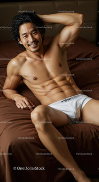 Smiling muscular man relaxing on bed in white underwear