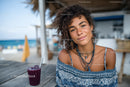 Young Woman Relaxing at Beachside Café with Drink