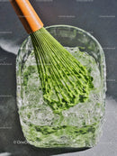 Green matcha whisk immersed in refreshing ice water