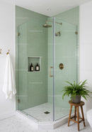 Modern glass shower with green tiles and brass fixtures