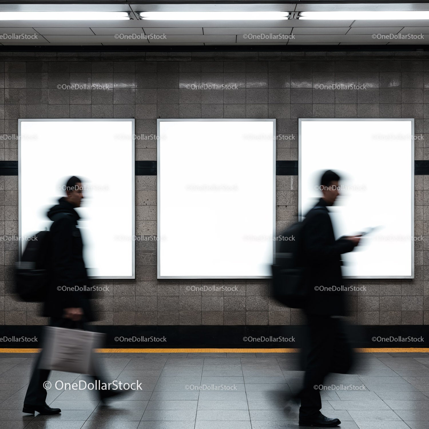 Blurred commuters passing empty advertisement panels in subway