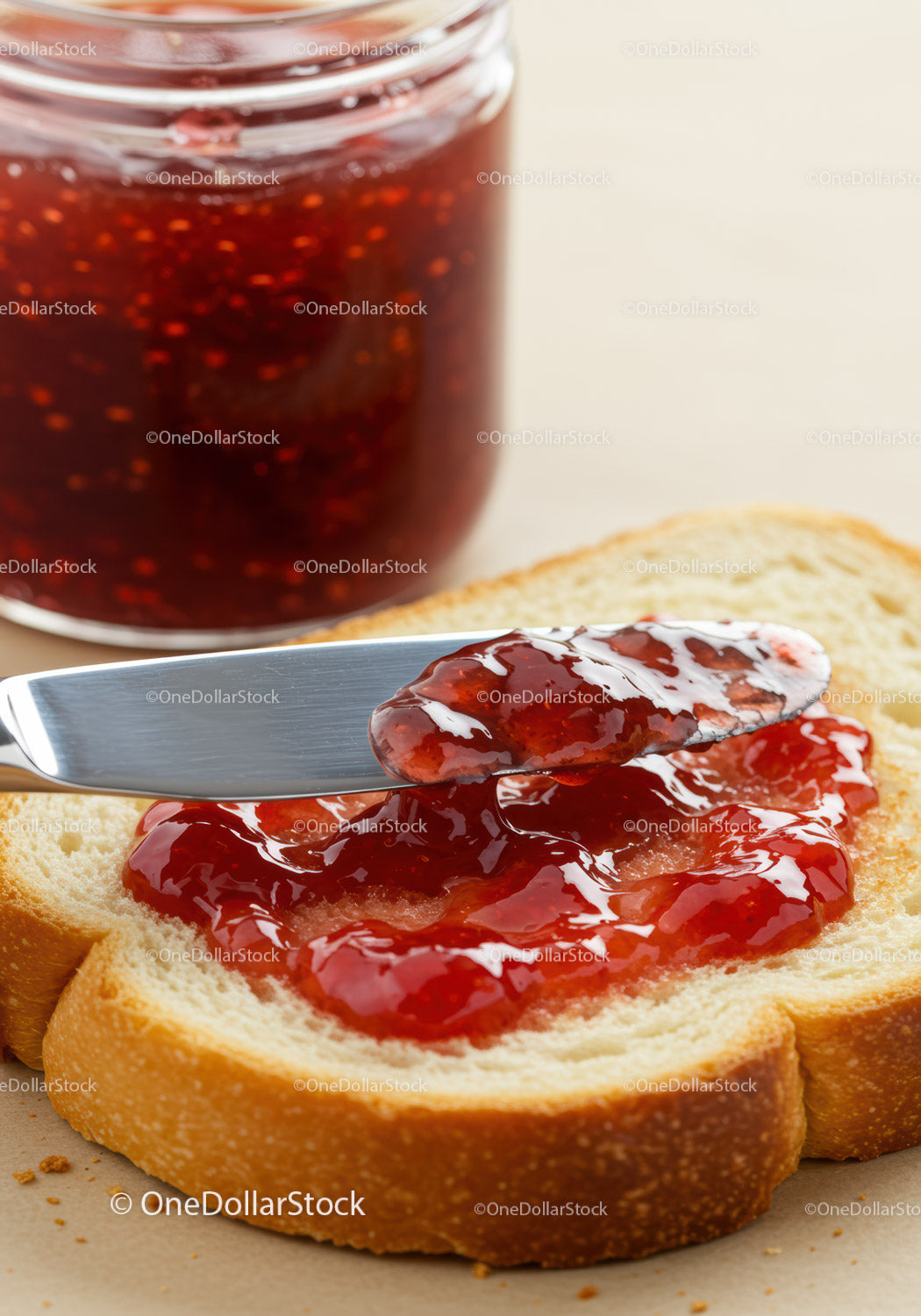 Spreading Fresh Strawberry Jam on Soft White Bread Slice