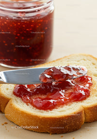 Spreading Fresh Strawberry Jam on Soft White Bread Slice