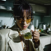 Stylish Woman in Sunglasses Enjoying Herbal Tea in Bright Kitchen