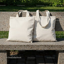 Two Blank Canvas Tote Bags on Outdoor Stone Bench