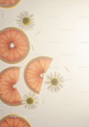 Fresh grapefruit slices with white daisies floating