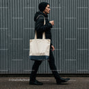 Man walking with tote bag in urban street setting