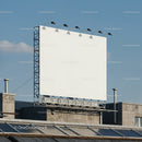 Blank outdoor billboard on urban rooftop against sky