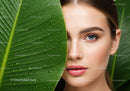 Young Woman with Blue Eyes and Fresh Green Leaf with Water Droplets