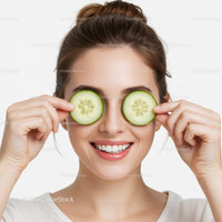 Bright Smiling Woman Holding Cucumber Slices Over Eyes for Skincare