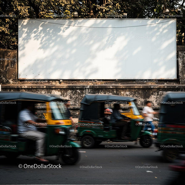 Busy street scene with moving auto rickshaws and blank billboard JPG Mockup Image