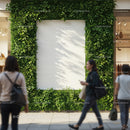 Urban green wall with blank white poster and walking people