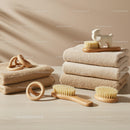 Stacked neutral towels with wooden brushes and rings